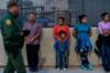 Мигранты, в основном из Центральной Америки, ждут, чтобы сесть в фургон, который отвезет их в центр обработки