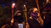 Женщины, закрывающие лица черными шарфами, демонстрируют, неся факелы