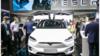 Люди рассматривают электромобиль Tesla Model 3 на автомобильной выставке третьей Международной импортной выставки в Шанхае, Китай, 6 ноября 2020 г.