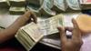Сотрудник считает банкноты Индии на кассе в банке