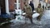 военнослужащие помогают раздавать мешки с песком жителям после наводнения в Карлайле