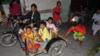 Жители Паданга катаются на скутере и коляске, когда они мчатся на возвышенность