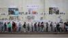 Люди выстраиваются в очередь, чтобы отдать свой голос перед «стеной Леннона», украшенной рваными плакатами