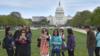 Группа китайских туристов фотографируется на Национальной аллее на фоне Капитолия США