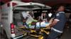 Раненого заключенного несут на носилках в больницу парамедики полиции после перестрелки среди заключенных в тюрьме Ла-Джойита, Панама-Сити, Панама 17 декабря 2019 г.