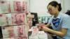 Сотрудник китайского банка считает банкноты 100 юаней и долларовые банкноты на кассе банка в Наньтуне в восточной провинции Китая Цзянсу 28 августа 2019 года.