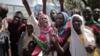 Суданские мужчины и женщины празднуют 17 августа 2019 года у Зала дружбы в столице Хартуме, где генералы и лидеры протеста подписали историческую переходную конституцию, призванную проложить путь к гражданскому правлению в Судане