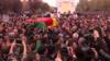 Гроб г-на Эльчи несут через огромные толпы, задрапированные красным, желтым и зеленым курдским флагом