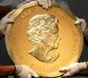 На снимке, сделанном в Вене, Австрия, 25 июня 2010 года, показаны эксперты австрийской экспедиторской компании, владеющие одной из крупнейших золотых монет в мире - канадским «Большим кленовым листом» 2007 года за 1 000 000 долларов. Идентичная монета была украдена из берлинского музея Боде 27 марта 2017 года.