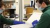 Сотрудники лаборатории открывают ящик с вакциной
