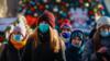 Русские люди в защитных масках идут по улице, украшенной к предстоящим празднованиям Рождества и Нового года во время пандемии коронавируса SARS-CoV-2 Москва, Россия, 28 декабря 2020 г.