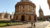 Люди проходят мимо здания Оксфордского университета