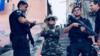 Мадонна позирует с военной полицией с оружием в трущобах Рио-де-Жанейро.