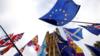 Флаги активистов ЕС, выступающих против Брексита, изображены рядом с флагами Союза активистов, выступающих за Брексит, во время демонстрации перед зданием парламента в Лондоне 28 октября 2019 года