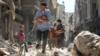 Сирийские мужчины несут младенцев среди завалов в Алеппо, сентябрь 2016 г.