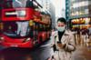 Женщина в маске ждет на остановке лондонского автобуса
