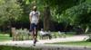Мужчина едет на электросамокате по парку Сент-Джеймс в центре Лондона