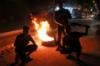Молодые люди блокируют дорогу горящими шинами во время акций протеста в городе Бенгази на восточном побережье Ливии 12 сентября 2020 года.