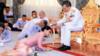 На раздаточной фотографии Королевского семейного бюро изображен тайский король Маха Ваджиралонгкорн Бодиндрадебаяварангкун (справа) наливает свадебную воду генералу Сутиде Ваджиралонгкорн на Аюдхья