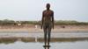 Статуя «Другое место» Энтони Гормли на пляже Кросби