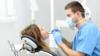 Стоматолог лечит пациента в маске