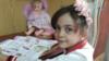 Бана Алабед, сидящая за столом с книгой и куклой, из своего аккаунта в Twitter