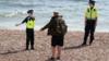 Полиция инструктирует пешехода на пляже в Британии, Восточный Суссекс