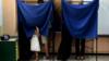 Ребенок смотрит из-за занавески кабины для голосования, пока взрослые голосуют на выборах в Греции