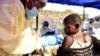 Конголезский медицинский работник вводит вакцину против Эболы ребенку в Медицинском центре Химби в Гоме