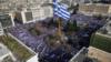 Люди держат греческие флаги, демонстрируя, что они призывают правительство не идти на компромисс в разгорающейся череде имен с соседней Македонией, на площади Синтагма в Афинах, 4 февраля 2018 г.