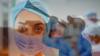 Медицинский работник из Южной Африки в маске наложил на фотографию человека, дующего в вувузелу