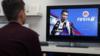 Мужчина играет в ФИФА 19. По телевизору можно увидеть изображение Криштиану Роналду в форме Ювентуса.