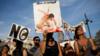 Женщина держит плакат с надписью на испанском: «Поставьте себя на его место», протестуя вместе с другими против корриды в Мадриде