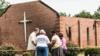 Люди молятся возле сгоревших руин церкви Mt Zion AME в Гриливилле, Южная Каролина. Гора Сион стала седьмой черной церковью на юге США, сожженной менее чем за две недели