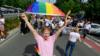 Мужчина машет флагом на гей-параде в Польше, 2019