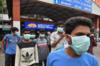 Молодые туристы носят маски в качестве превентивной меры против распространения вспышки коронавируса COVID-19 на железнодорожном вокзале Бангалора 4 марта 2020 года.