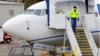 Рабочий Boeing спускается со ступенек самолета в маске
