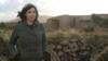Женщина стоит рядом с укреплениями времен Второй мировой войны