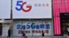 Люди проходят мимо рекламы China Telecom 5G 25 июля 2019 года в Пекине, Китай