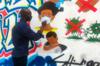 Конголезский художник Крис Шонго рисует фреску в Киншасе.