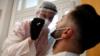 Медицинский работник проверяет кого-то на коронавирус в Париже