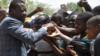 Фор Гнасингбе (слева) обменивается рукопожатием со сторонниками во время своего визита в военный госпиталь в деревне Намундджога на севере Того 17 февраля 2020 года.
