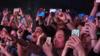 Концерт с людьми, держащими в руках смартфоны