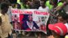 Демонстранты держат плакат с изображением президента Либерии Джорджа Веа, когда они собираются возле особняка Либерии в Монровии 7 июня 2019 года во время антиправительственного марша протеста против инфляции и коррупции.