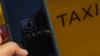 На этой фотографии 1 июля 2014 г. на мобильном телефоне рядом с такси отображается логотип нового приложения для смартфонов «Uber»