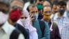 Люди в защитных масках стоят в очереди, чтобы сесть в автобус на фоне распространения коронавирусной болезни (COVID-19) в Мумбаи, Индия, 6 октября 2020 г.