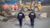Два полицейских идут к бригаде подрывников на месте бывшего лагеря в Кале