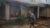 Мужчина проходит мимо горящего дома в Колиньи, который, как сообщается, был подожжен протестующими во время столкновений, вспыхнувших после того, как суд освободил двух мужчин, обвиняемых в убийстве мальчика 8 мая 2017 года
