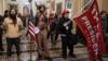 Протест на выборах в США: Джейкоб Ченсли (в центре) с другими сторонниками Трампа во время демонстрации вне Палаты Сената в Капитолии США после нарушения безопасности, 6 января 2021 года