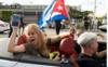 Люди реагируют на известие о смерти бывшего президента Кубы Фиделя Кастро у ресторана Versailles 26 ноября 2016 года в Майами, Флорида.Многие, в основном кубинцы, собрались, чтобы помахать флагами и отпраздновать известие о смерти кубинского революционера